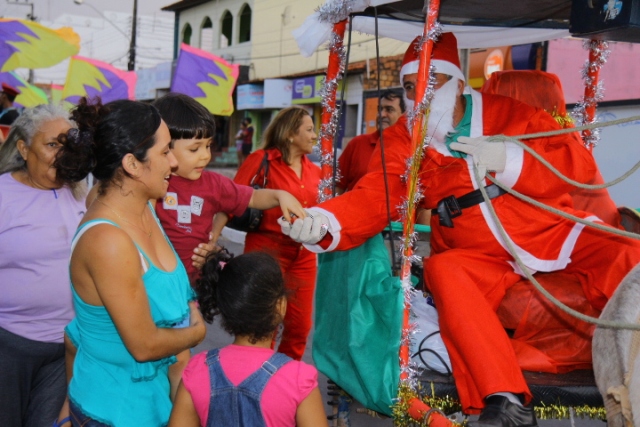 Papai Noel entrega doces a crianças durante sua passagem pelo conjunto Maiobão