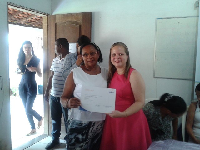 Uma das formandas recebe certificado de conclusão de curso das mãos da secretária da Mulher, Carla Sousa