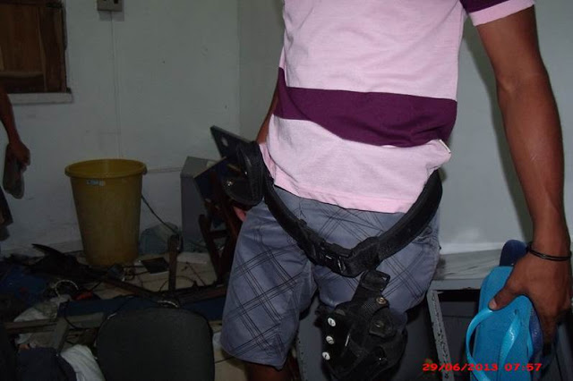 Homem usa cinturão encontrado entre objetos e documentos revirados no prédio do destacamento da PM do município