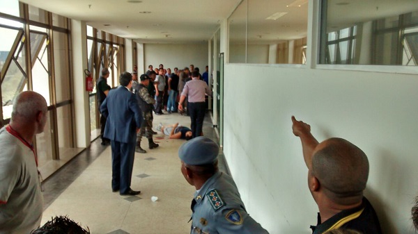 Erinaldo Almeida Soeiro caído no corredor do fórum após balear investigador e ser alvejado por outro policial 