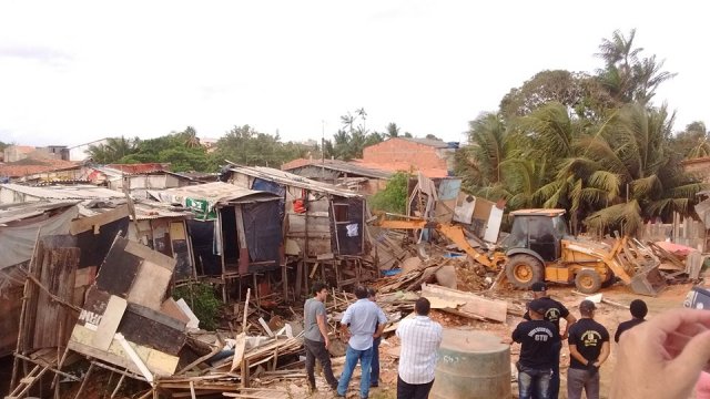 Escavadeira avança sobre palafitas durante a operação de desocupação da margem da avenida 