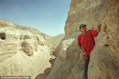 FILE - In this Thursday, July 26, 2001 file photo, Roi Porat, an Israeli student of archaeology, works near the remains of a cave found at the West Bank archeological site of Qumran, near the Dead Sea Thursday, July 26, 2001. An Israeli antiquities official says Israel is embarking on a major expedition to find more Dead Sea Scrolls and other artifacts. (AP Photo/Lefteris Pitarakis, File)